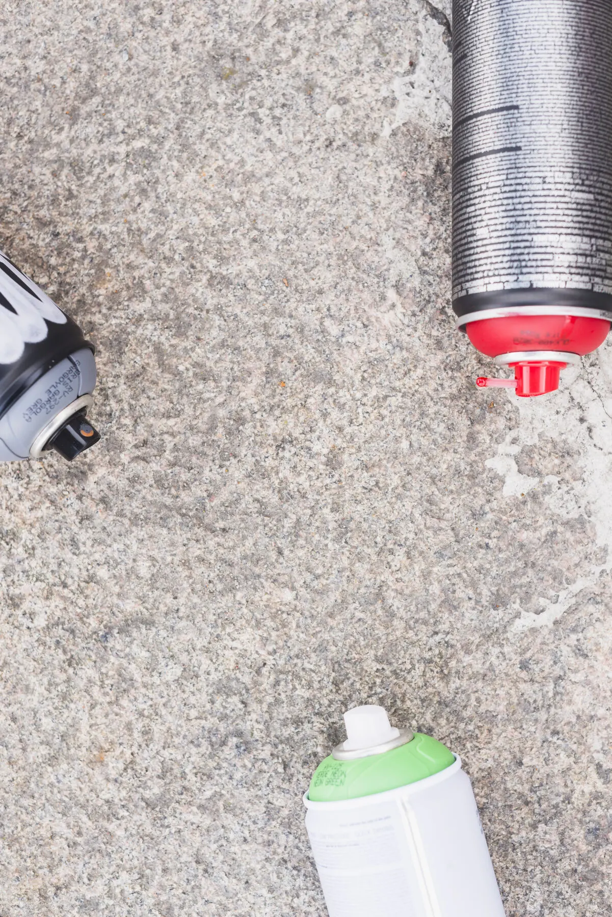 Varios botes de pintura en aerosol sobre una superficie con textura